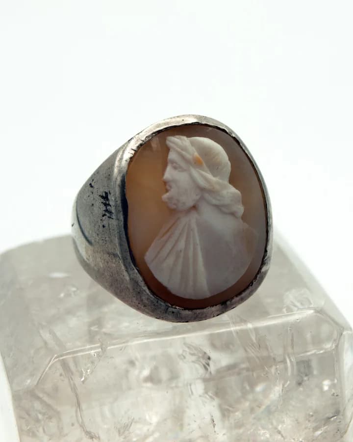 A ring with an oval cameo carved in profile, resting on a block of crystal